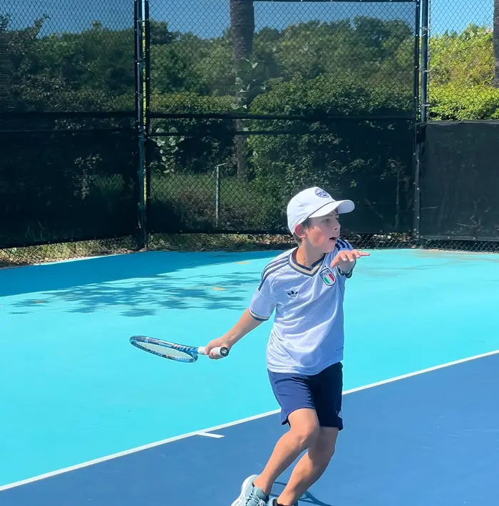 Junior player hitting a forehand on court